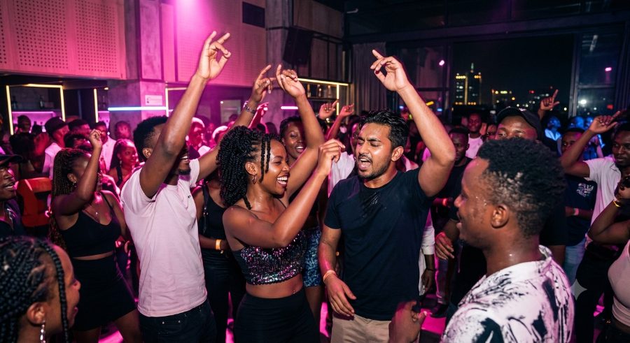 crowd dancing under pink lights at a club night